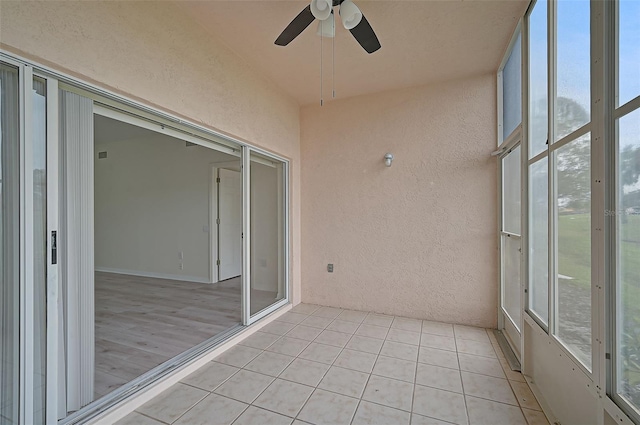 unfurnished sunroom with ceiling fan