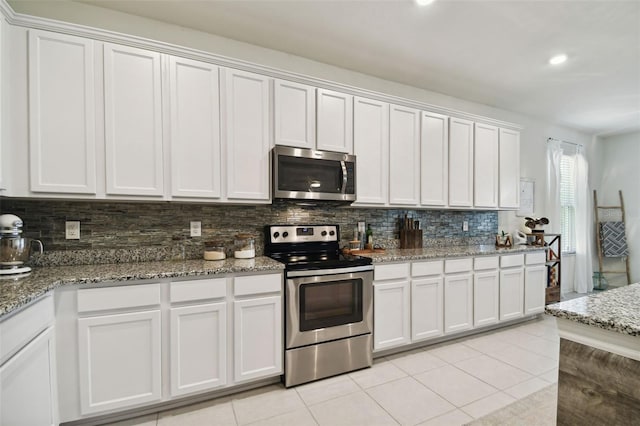 kitchen with white cabinetry, tasteful backsplash, stainless steel appliances, and light tile patterned floors