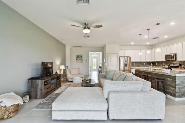 tiled living room with sink and ceiling fan