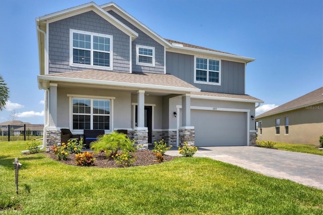 craftsman inspired home featuring a garage and a front lawn