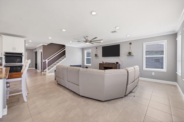 tiled living room featuring crown molding and ceiling fan