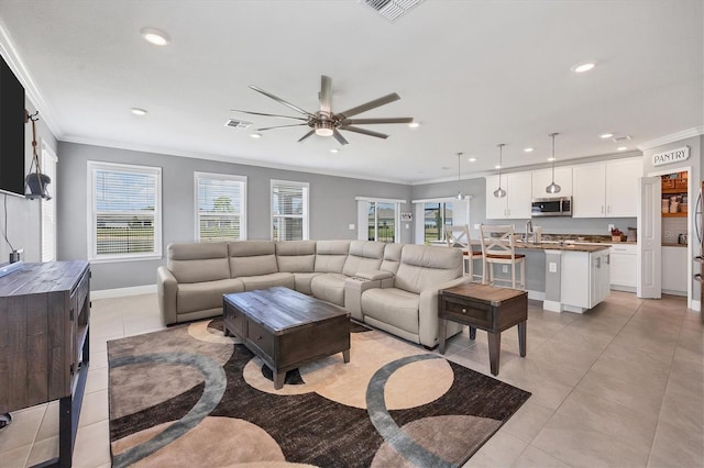 living room with sink, crown molding, light tile patterned floors, and ceiling fan