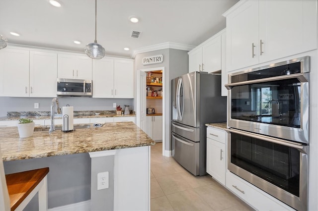 kitchen featuring appliances with stainless steel finishes, crown molding, white cabinetry, and hanging light fixtures