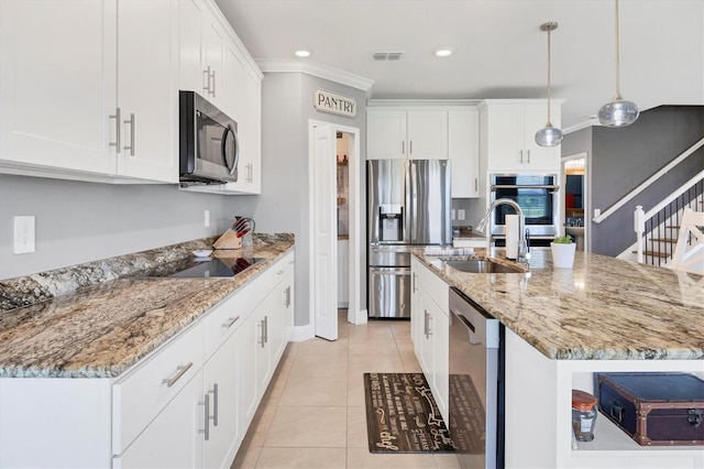 kitchen with hanging light fixtures, white cabinetry, sink, crown molding, and stainless steel appliances