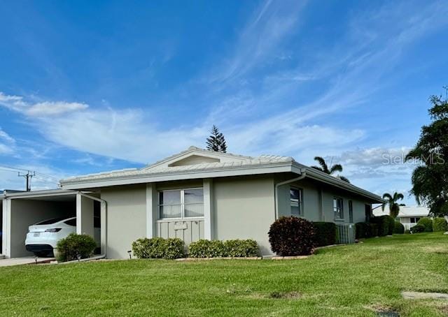 view of side of home with a lawn and a carport