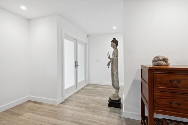 entryway with plenty of natural light, french doors, and light wood-type flooring