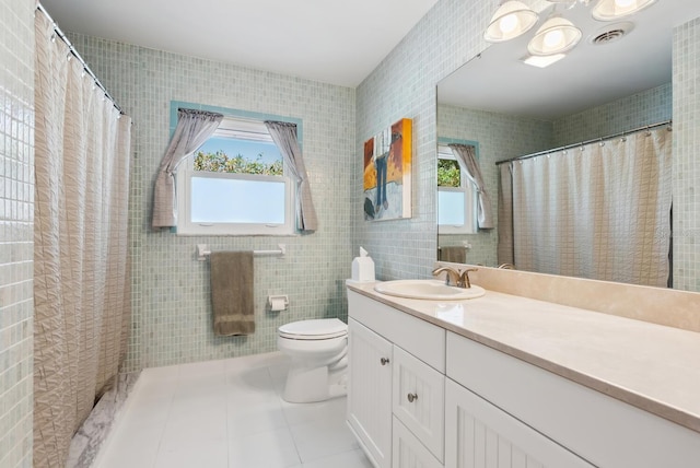 bathroom with vanity, toilet, tile walls, and plenty of natural light