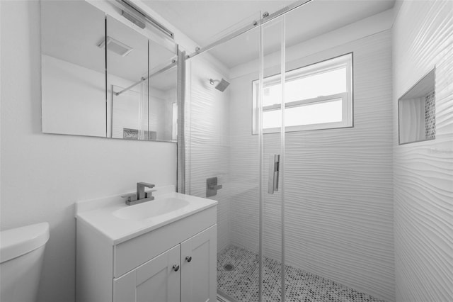 bathroom with vanity, a shower with shower door, and toilet