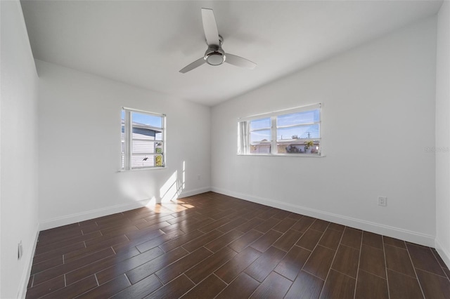 empty room featuring lofted ceiling, plenty of natural light, dark hardwood / wood-style floors, and ceiling fan