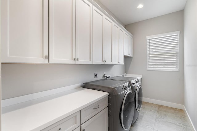 laundry room with cabinets, separate washer and dryer, and light tile patterned flooring