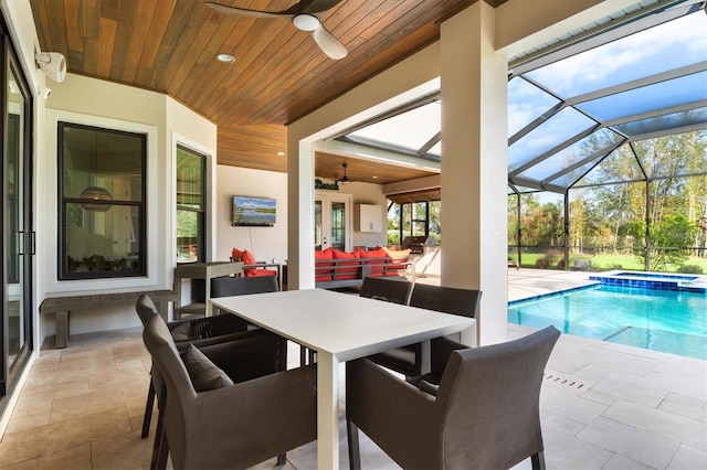 exterior space featuring an in ground hot tub, an outdoor living space, ceiling fan, glass enclosure, and a patio area