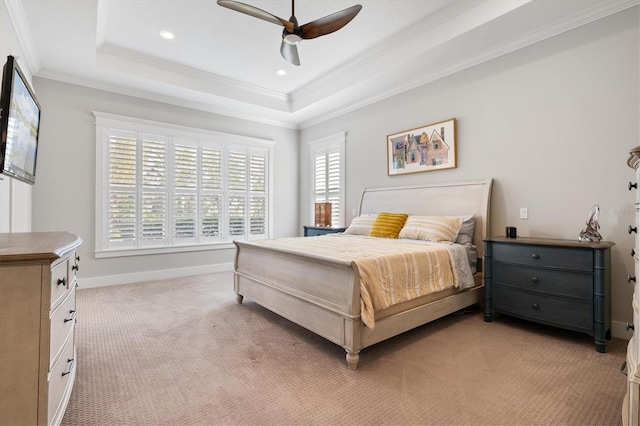 bedroom featuring baseboards, a raised ceiling, crown molding, and light colored carpet