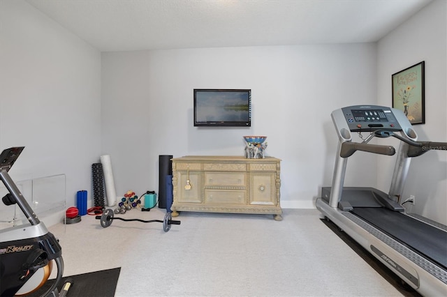 workout room with baseboards and carpet flooring