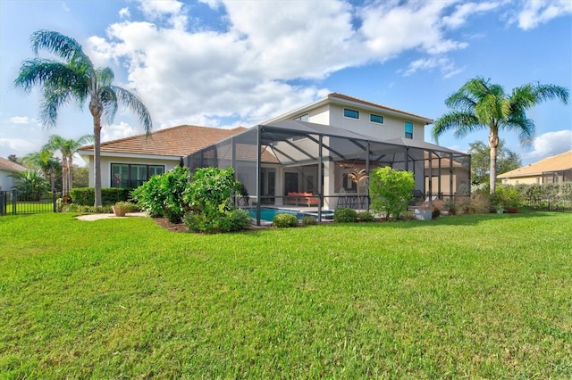 back of property with an outdoor pool, a lawn, a lanai, fence, and stucco siding