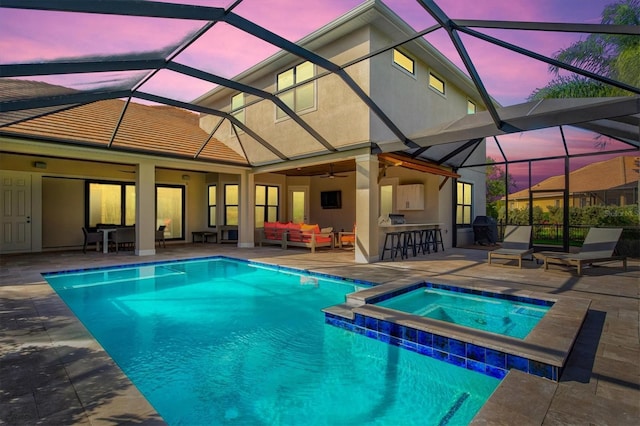 pool at dusk with a lanai, outdoor lounge area, a patio, and outdoor dry bar