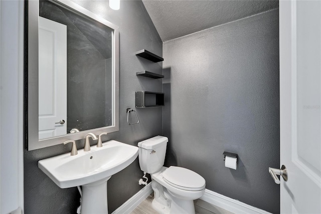 bathroom featuring sink, a textured ceiling, and toilet