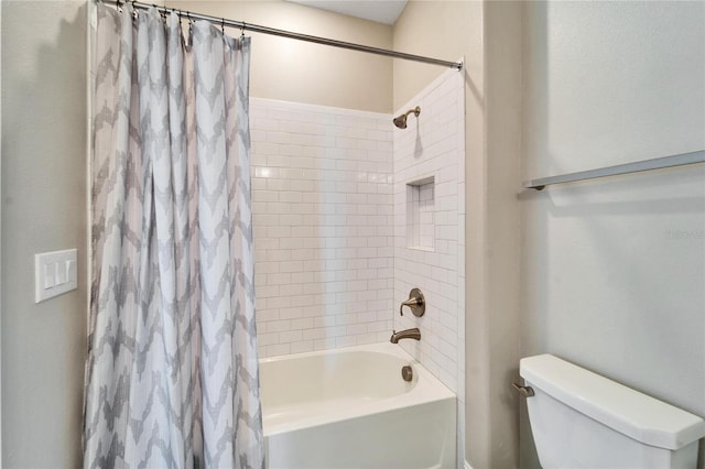 bathroom with shower / bath combination with curtain and toilet