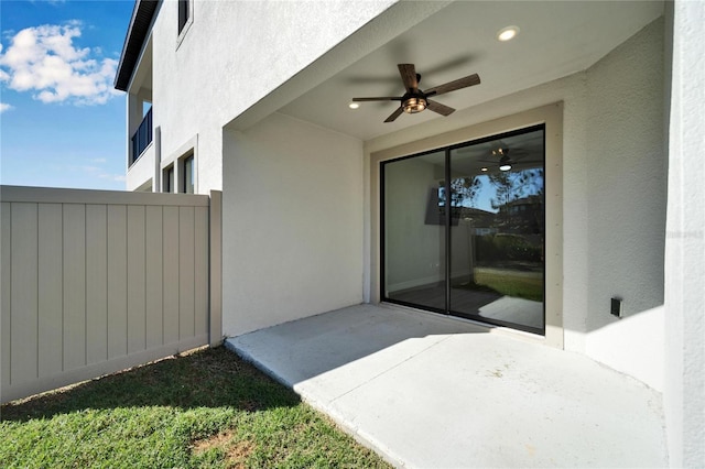 view of exterior entry with a patio area and ceiling fan