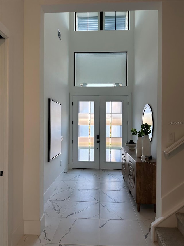 doorway to outside featuring french doors and a towering ceiling