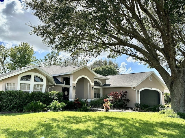 single story home featuring a front lawn and a garage