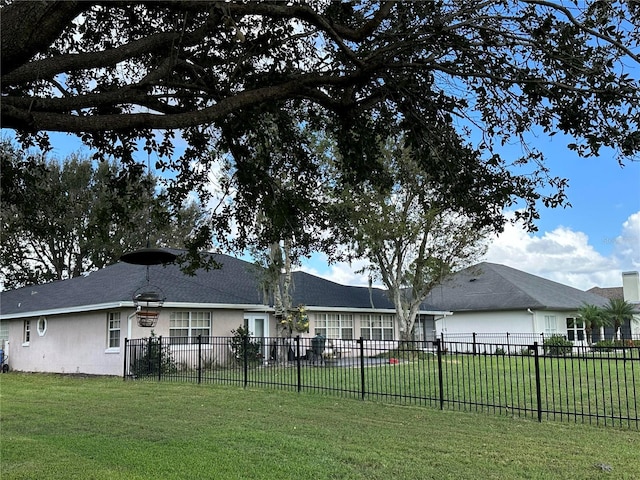 back of property featuring a yard, stucco siding, and fence