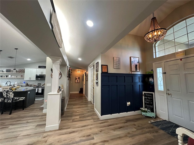 entryway featuring an inviting chandelier, light wood finished floors, and baseboards