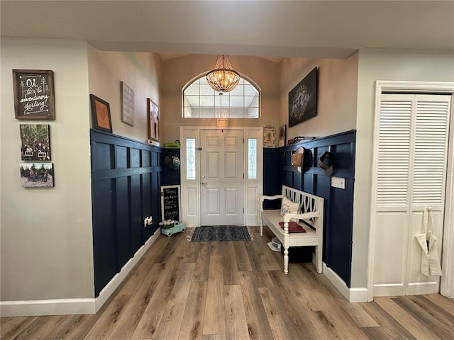 foyer entrance featuring an inviting chandelier, wood finished floors, and baseboards