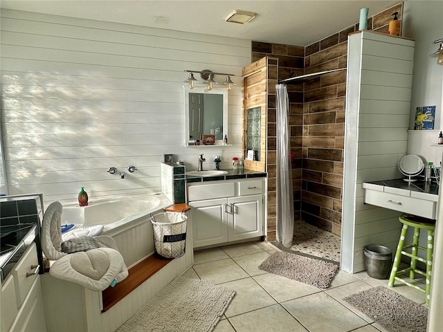 bathroom featuring a garden tub, a stall shower, tile patterned floors, and vanity