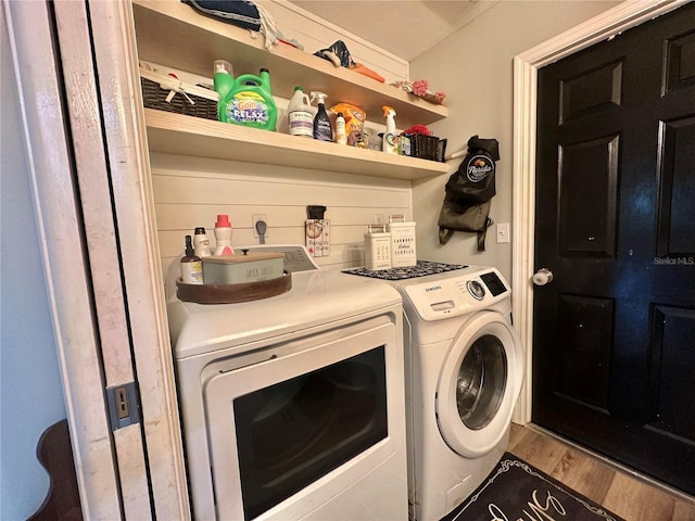 clothes washing area featuring wood finished floors, independent washer and dryer, and laundry area