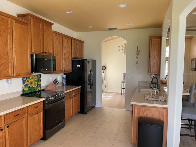 kitchen with light hardwood / wood-style flooring, black appliances, and sink