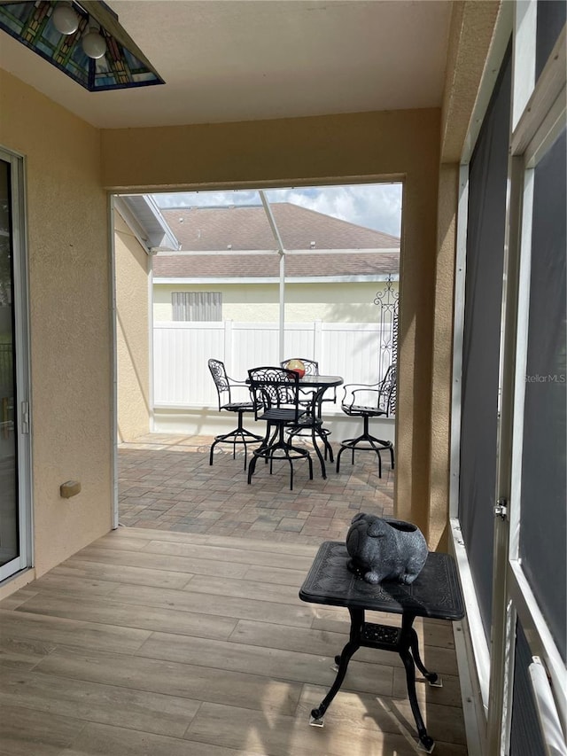 wooden deck with a patio area and glass enclosure