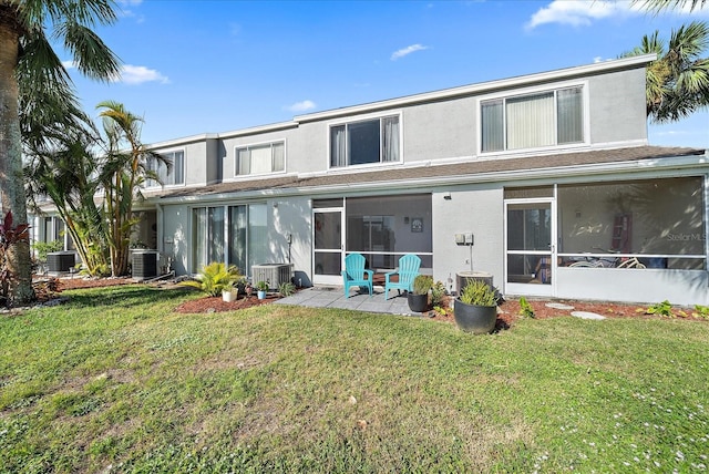 rear view of house with a yard, a sunroom, central AC, and a patio