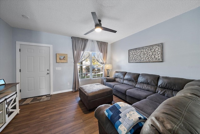 living room featuring a textured ceiling, dark wood-type flooring, and ceiling fan