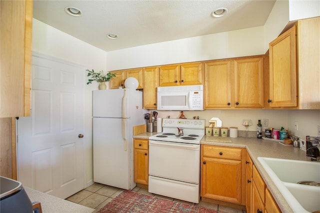 kitchen with sink, white appliances, and light tile patterned floors