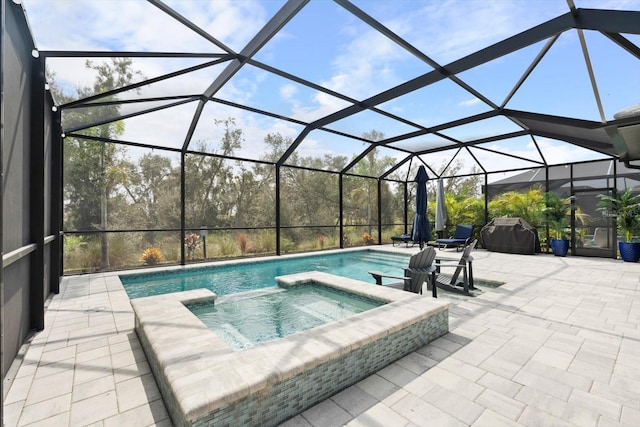 view of pool featuring glass enclosure, a patio, and an in ground hot tub