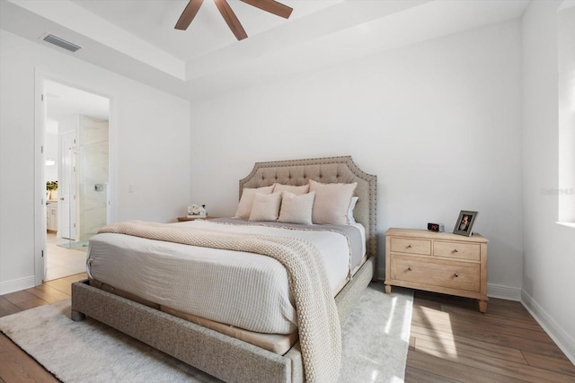 bedroom featuring ensuite bath, hardwood / wood-style flooring, and ceiling fan