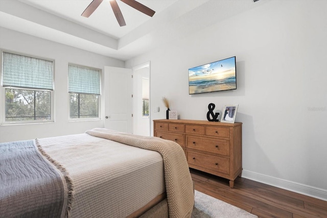 bedroom with dark hardwood / wood-style flooring and ceiling fan