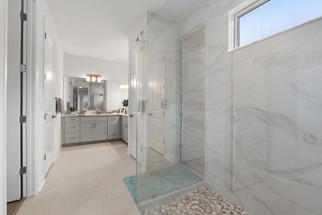 bathroom with tiled shower and vanity