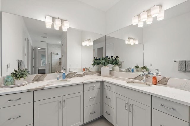 bathroom featuring a shower with shower door and vanity