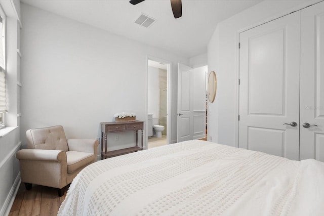 bedroom with hardwood / wood-style floors, ceiling fan, connected bathroom, and a closet