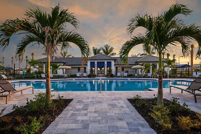 pool at dusk with a patio