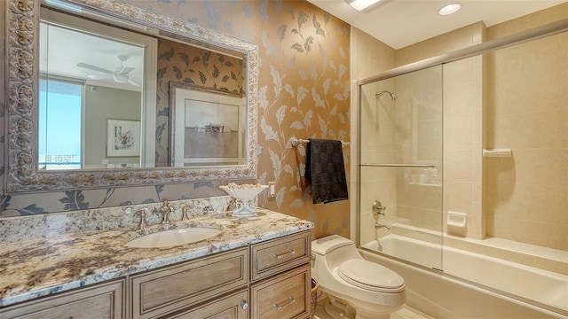 full bathroom featuring enclosed tub / shower combo, ceiling fan, toilet, and vanity