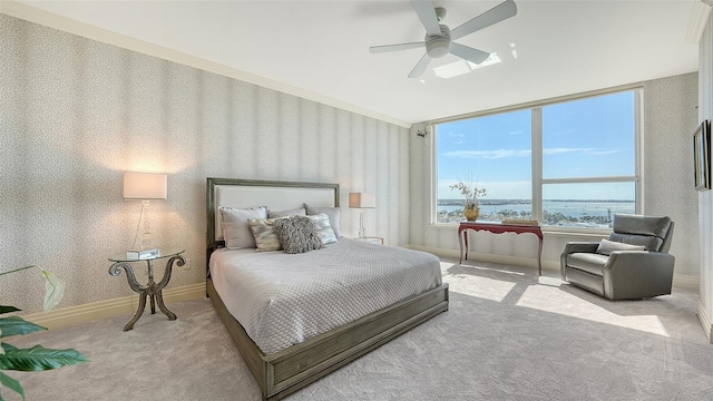 carpeted bedroom with a water view and ceiling fan