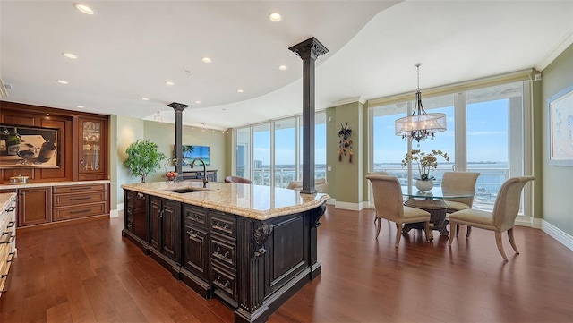 kitchen with plenty of natural light, a water view, sink, and dark wood-type flooring