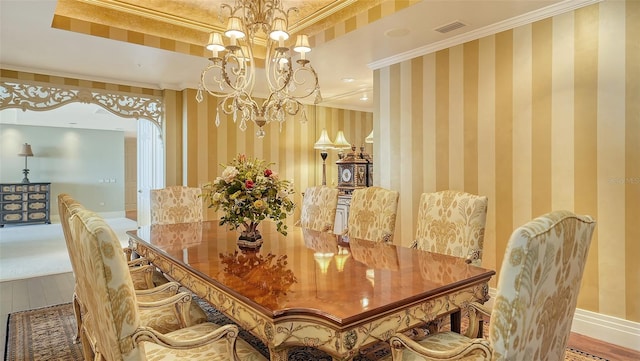 dining area with hardwood / wood-style floors, a notable chandelier, and crown molding