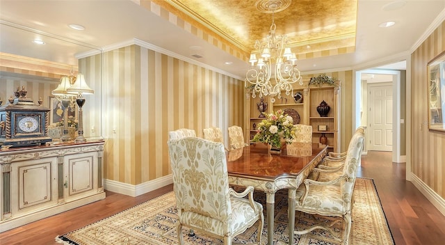 dining space featuring hardwood / wood-style floors, a notable chandelier, ornamental molding, and a raised ceiling