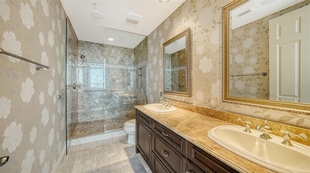 bathroom with toilet, vanity, and a shower with shower door