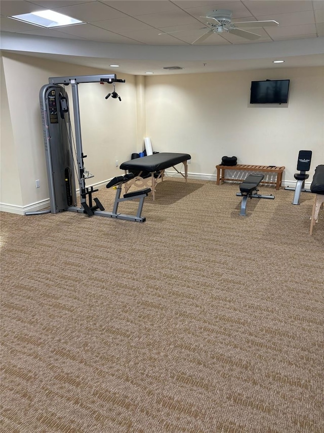 exercise room with a paneled ceiling and carpet