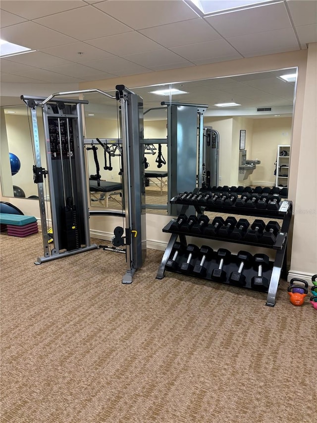 workout area with a paneled ceiling and carpet flooring