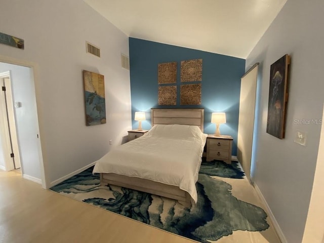 bedroom with hardwood / wood-style floors and vaulted ceiling